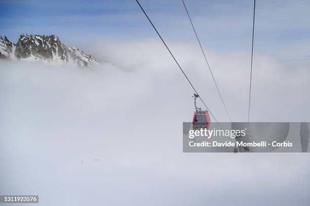 Group of athletes in the dense peak are climbing the Presena peak under the cable car during Adamello Ski Raid on April 10, 2021 in Ponte di Legno -...