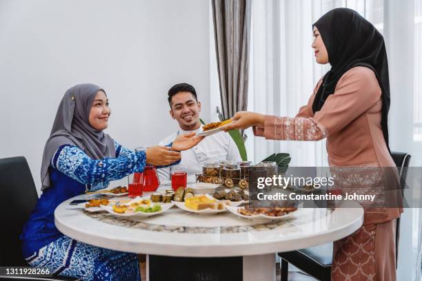 sharing meal during hari raya celebration - ramadan dates stock pictures, royalty-free photos & images