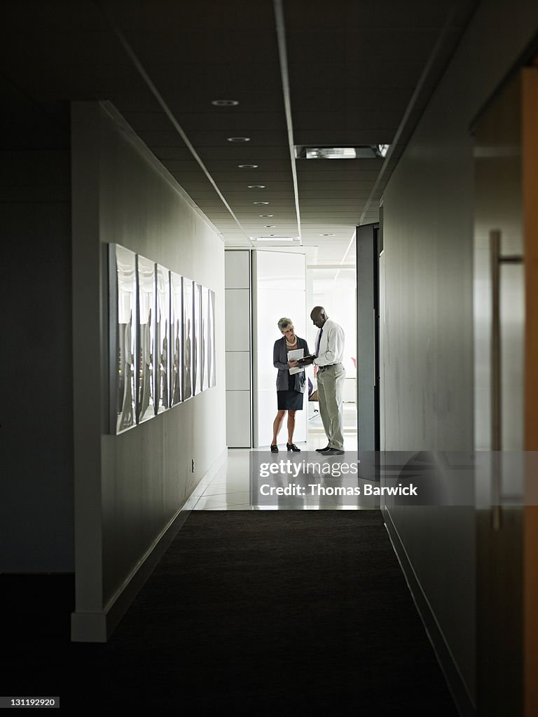 Businessman and businesswoman in hallway