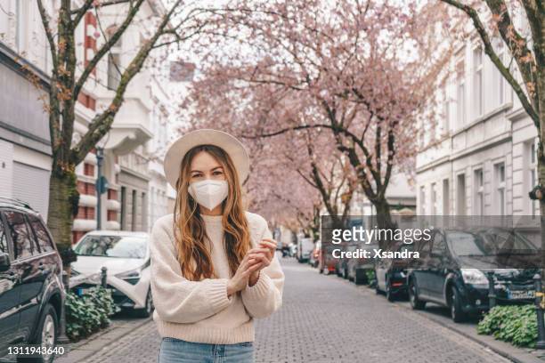 woman wearing a medical mask outdoors - bonn stock pictures, royalty-free photos & images