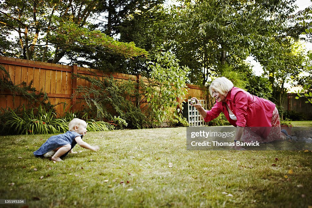 Grandmother taking digital photo of granddaughter