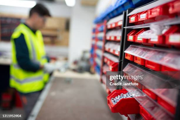 engineer with protecive gloves taking material from the warehouse. - nut fastener stock pictures, royalty-free photos & images