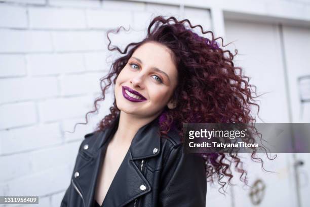 fashion teenager girl with curly hair and purple lips posing smiling - latvia girls stock pictures, royalty-free photos & images