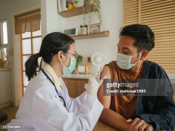 latin man being covid-19 vaccinated at home. - respiratory disease stock pictures, royalty-free photos & images