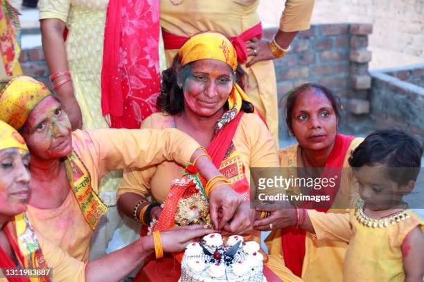 group of rural women celebrating birthday of bal krishna (lord krishna) - krishna janmashtami stock pictures, royalty-free photos & images