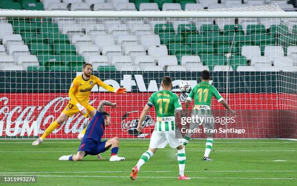 Cristian Tello of Real Betis scores their side's first goal past Jan Oblak of Atletico de Madrid during the La Liga Santander match between Real...