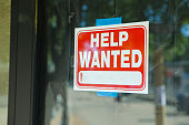 Help wanted sign in front of store front