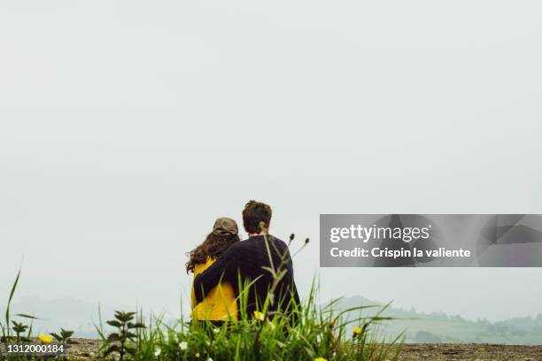 back view of a couple hugging contemplating the natural landscape - en el centro fotografías e imágenes de stock