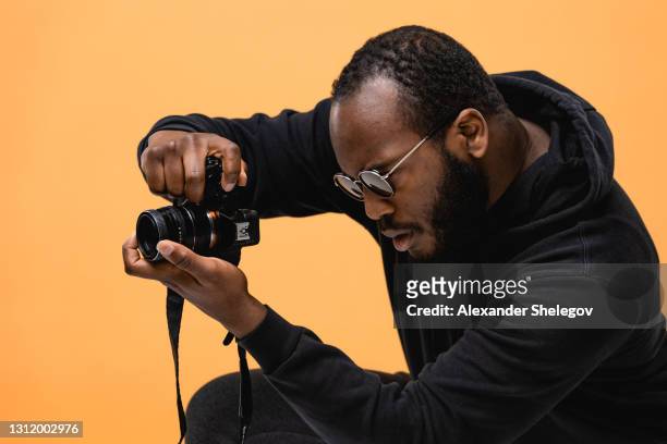 porträt des bart afroamerikanischen professionellen kameramann mit brille im studio. - photographer stock-fotos und bilder