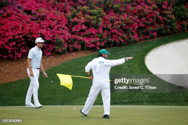 Corey Conners of Canada talks with his caddie Danny Sahl on the 13th green during the final round of the Masters at Augusta National Golf Club on...