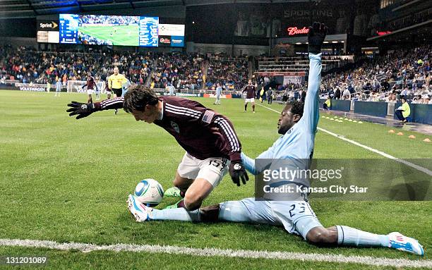 Sporting Kansas City forward Kei Kamara, right, saves the ball from going out as Colorado Rapids midfielder Wells Thompson sails over Kamara's leg in...