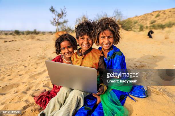 group of happy gypsy indian children using laptop, india - local gypsy stock pictures, royalty-free photos & images