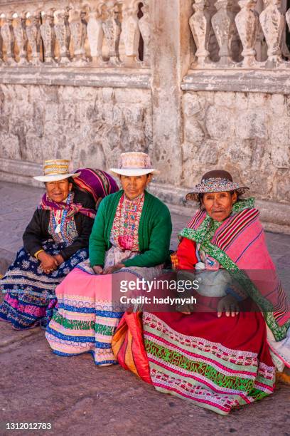 peruanische frauen in nationalkleidung ruhen auf der plaza de armas, chivay, peru - peruanische kultur stock-fotos und bilder