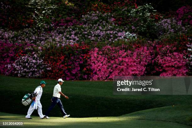 Hideki Matsuyama of Japan and his caddie, Shota Hayafuji, walk to the 13th green during the final round of the Masters at Augusta National Golf Club...
