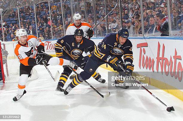 Mike Weber of the Buffalo Sabres defends Claude Giroux and Jaromir Jagr of the Philadelphia Flyers as teammate Robyn Regehr controls the puck behind...