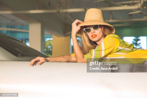 glamourous retro woman wearing beach hat and cat eye sunglasses on vacation - cats eye glasses photos et images de collection