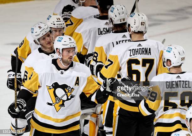 Brian Dumoulin and Jake Guentzel of the Pittsburgh Penguins celebrate the win over the New Jersey Devils at Prudential Center on April 11, 2021 in...