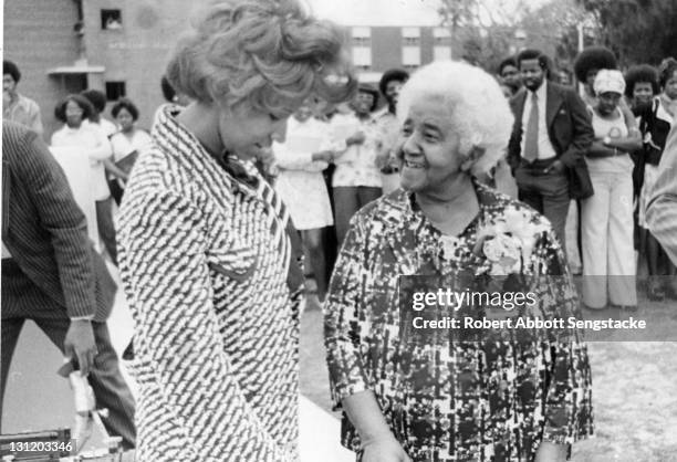 American inventor Marjorie Stewart Joyner speaks with an unidentified woman at an unidentified, outdoor event, late 1960s. Joyner was one of the...