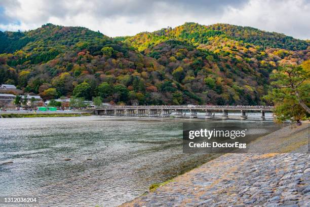 scenic view of togetsukyo bridge with  colourful mountain in autumn, arashiyama, kyoto, japan - 渡月橋 ストックフォトと画像