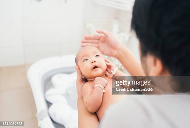 asian young adult father shower for his baby daughter in bathroom at home - baby shower - fotografias e filmes do acervo