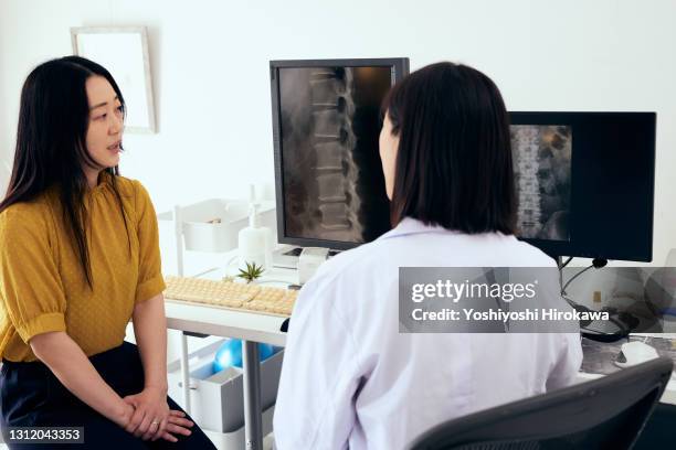 female doctor gives face-to-face explanation to patient - medische onderzoekskamer stockfoto's en -beelden