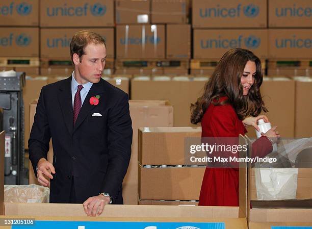 Prince William, Duke of Cambridge and Catherine, Duchess of Cambridge help to pack relief boxes as they visit the UNICEF emergency supply centre on...