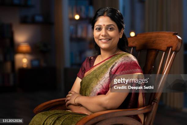 shot of a woman in sari sitting on a rocking chair at home:- stock photo - beautiful people stock pictures, royalty-free photos & images
