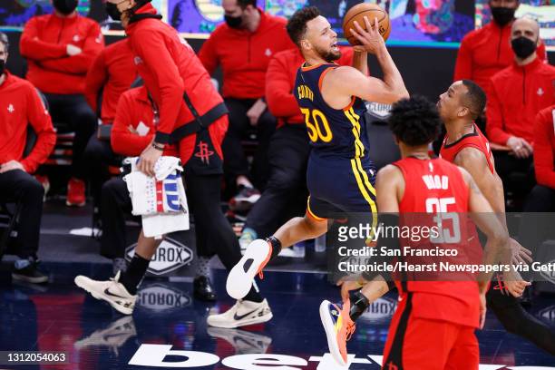 Golden State Warriors guard Stephen Curry is fouled outside the three-point line in the third quarter of an NBA game against the Houston Rockets at...