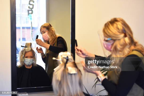 Amanda Sidley, owner of Bronte's Hair Boutique, cuts a customers hair after reopening on April 12, 2021 in Leek, England. England has taken a...