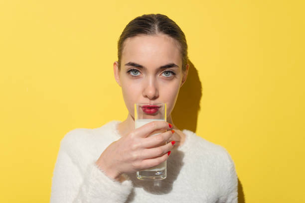 hispanic young woman drinking glass of milk - mulher bonita bebendo leite - fotografias e filmes do acervo
