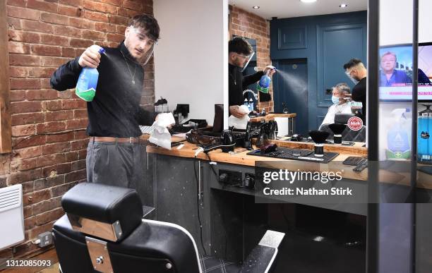 Barber cleans a chair before his next customer at The Men's Den Barber Shop on April 12, 2021 in Leek, England. England has taken a significant step...