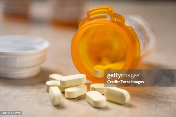 pills spilling out of prescription bottle - opioid stockfoto's en -beelden