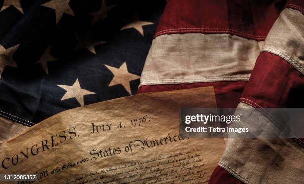 close-up of declaration of independence resting on american flag - unabhängigkeit stock-fotos und bilder
