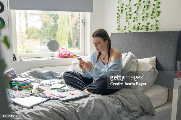 teenage girl studying in her bedroom - leselernkarte stock-fotos und bilder