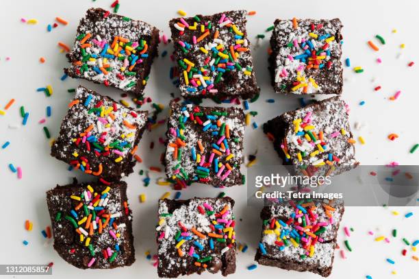 overhead view of freshly baked brownies covered with colorful sprinkles - brownie stockfoto's en -beelden