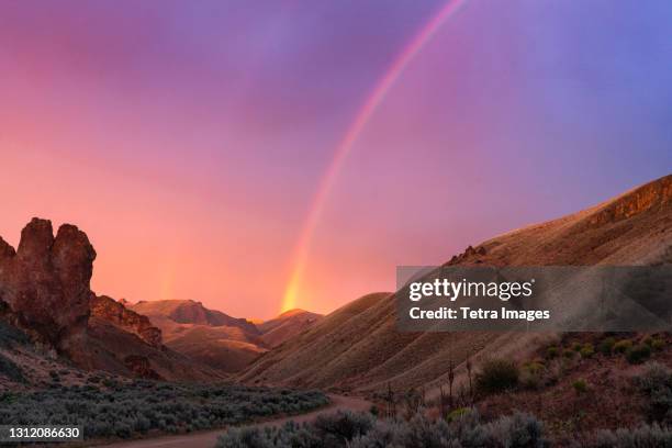 united states, oregon, rainbow above desert landscape at sunset - desert sky stock pictures, royalty-free photos & images