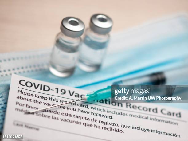 covid-19 vaccination record card, passport, vials, syringe and medical mask. immune passport or certificate for travel concept. - world health organisation bildbanksfoton och bilder