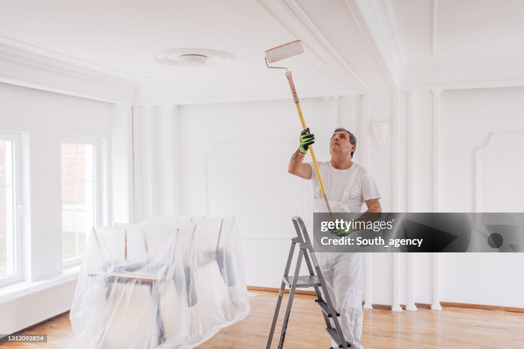 Male painter painting a ceiling