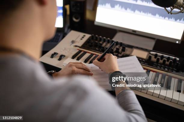 joven músico escribiendo canción para nuevo álbum en estudio de grabación en casa - composición fotografías e imágenes de stock