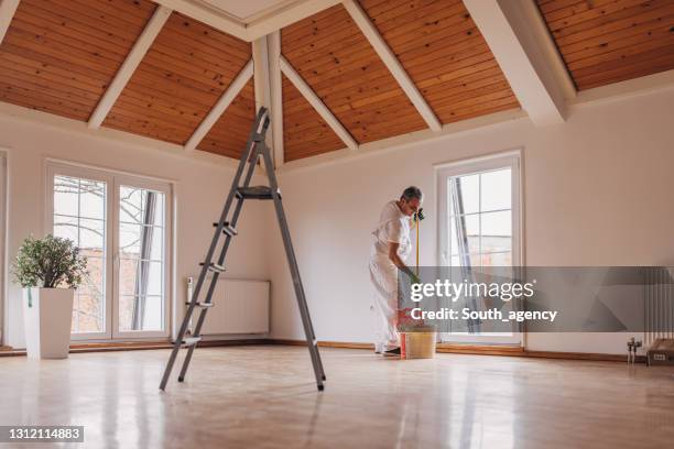 reife maler malerei eine wand - renovieren zimmer streichen stock-fotos und bilder