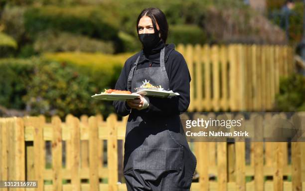 Lady serves food whilst in a beer garden at Hotel Rudyard on April 12, 2021 in Leek, England. England has taken a significant step in easing its...