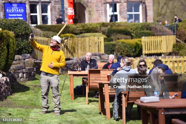 Man takes a selfie as he enjoys a drink in a beer garden at Hotel Rudyard on April 12, 2021 in Leek, England. England has taken a significant step in...