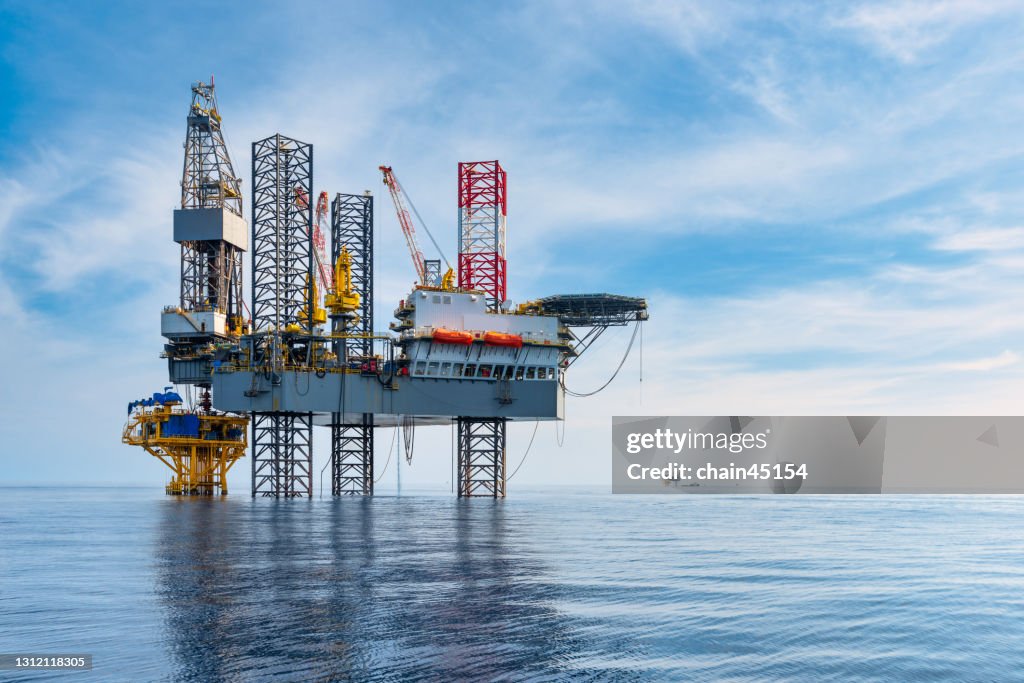 Oil rig type offshore Jack Up drilling rig in The Middle of The Sea drilling offshore well for oil and gas production industry.