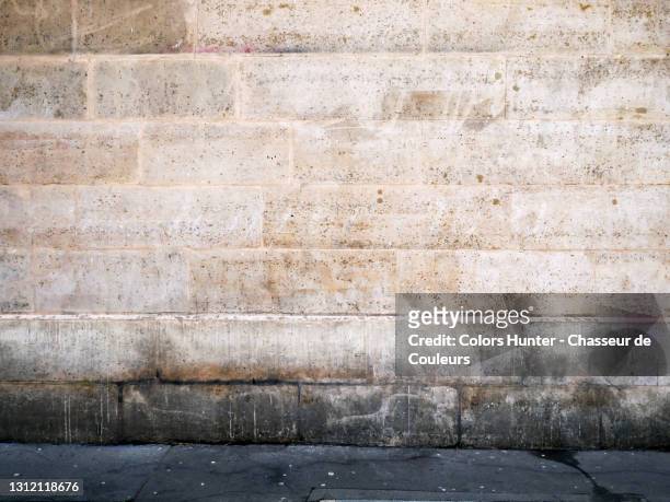 old stone wall and sidewalk with patina in paris left bank - le mur photos et images de collection