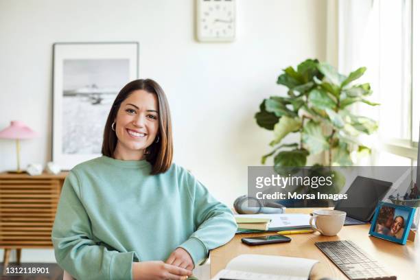 beautiful smiling entrepreneur at home office - casual clothing photos stock-fotos und bilder