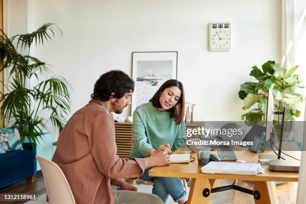 male and female colleagues working at home office - agenda meeting imagens e fotografias de stock
