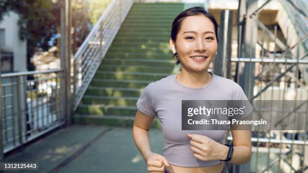 female athlete running outdoors - すらりとした ストックフォトと画像