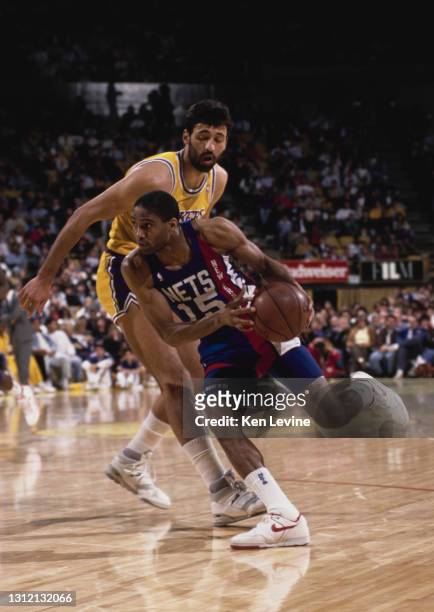 Lester Conner, Shooting Guard and Point Guard for the New Jersey Nets dribbles the basketball around Vlade Divac of the Los Angeles Lakers during...