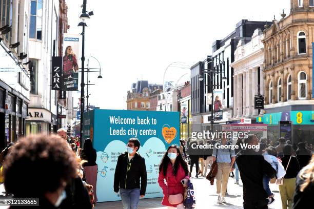 General view of a sign welcoming the public back to Leeds city centre as shoppers can be seen wearing face masks on Briggate as non-essential retail...