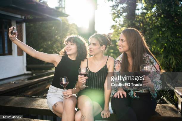 Friends taking a selfie relaxing at house outdoors - including two female transsexual